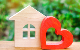 Wooden Shape House with Red Wooden Heart Beside It | Fall In Love with Homeownership