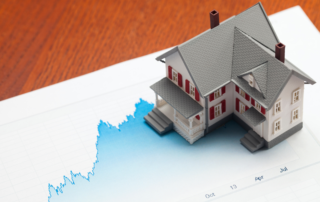 Miniature House on Top of a Paper with Graph || The Current Housing Shortage Helps Keep Home Prices from Crashing