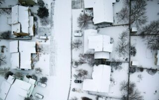 December Real Estate Market Review | Snow Covered Street Seen From Above.